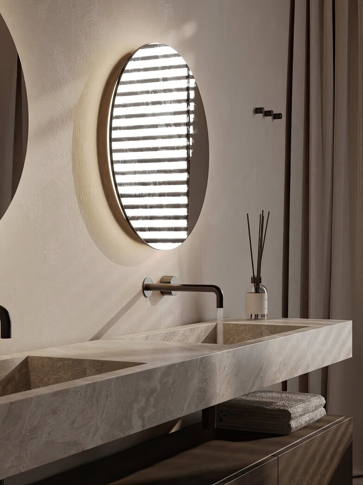 Salle de Bain Design : Miroir Rétroéclairé et Vasque Pierre Salle de bain moderne avec miroir rond rétroéclairé, vasque en pierre naturelle et robinetterie noire épurée.